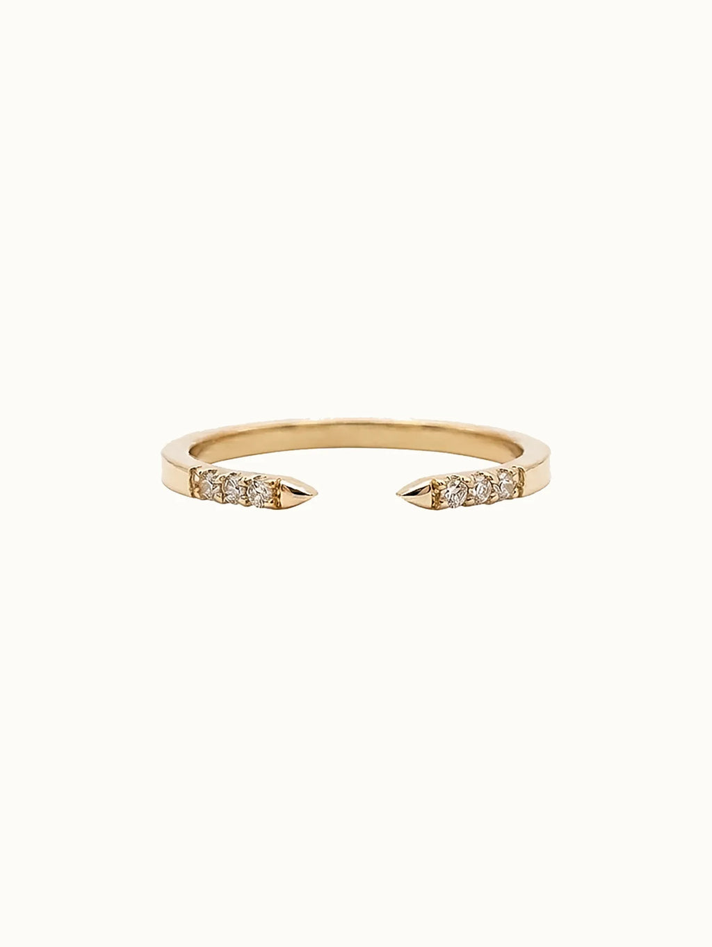 Gold open-ended ring with diamond accents on a white background