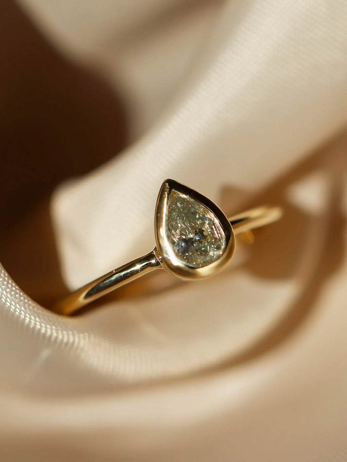 Gold ring with a teardrop-shaped warm diamond 