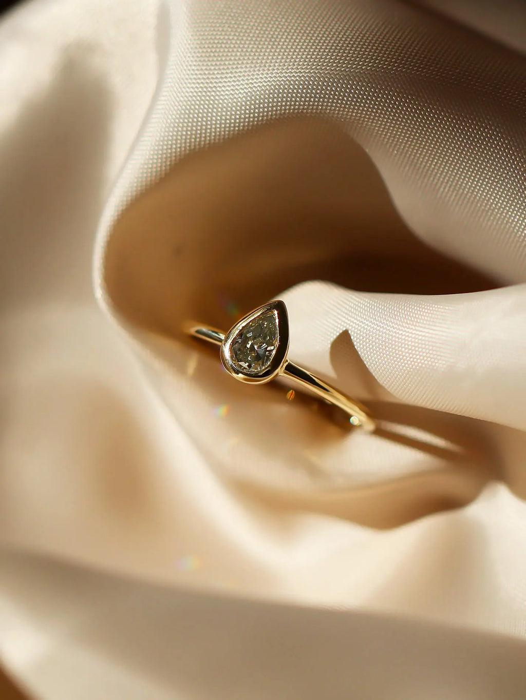 Gold ring with a pear shaped diamond with bezel setting